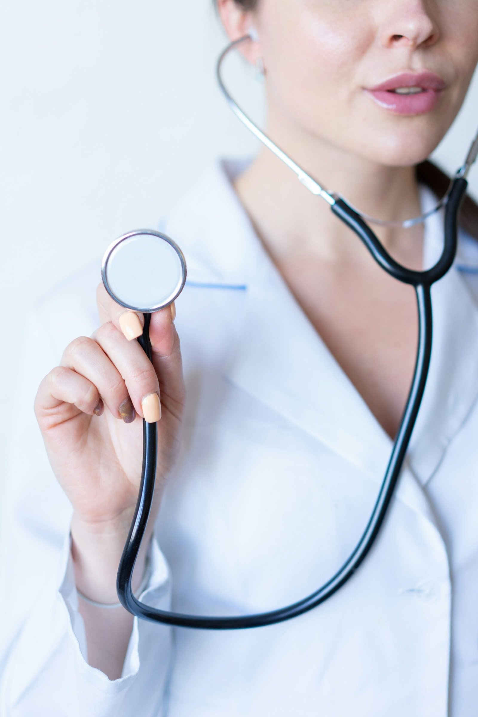 a woman in a white shirt holding a stethoscope